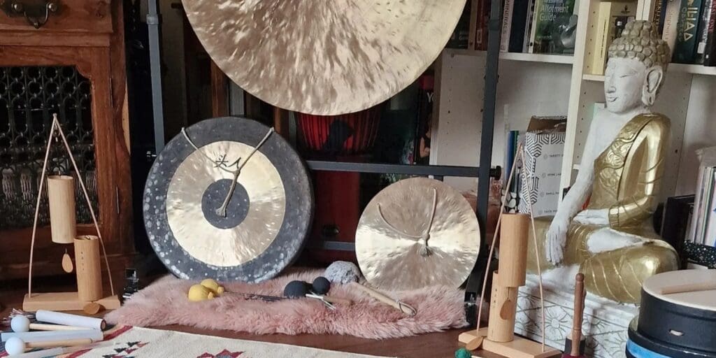 Gongs and Buddha statue in a room.